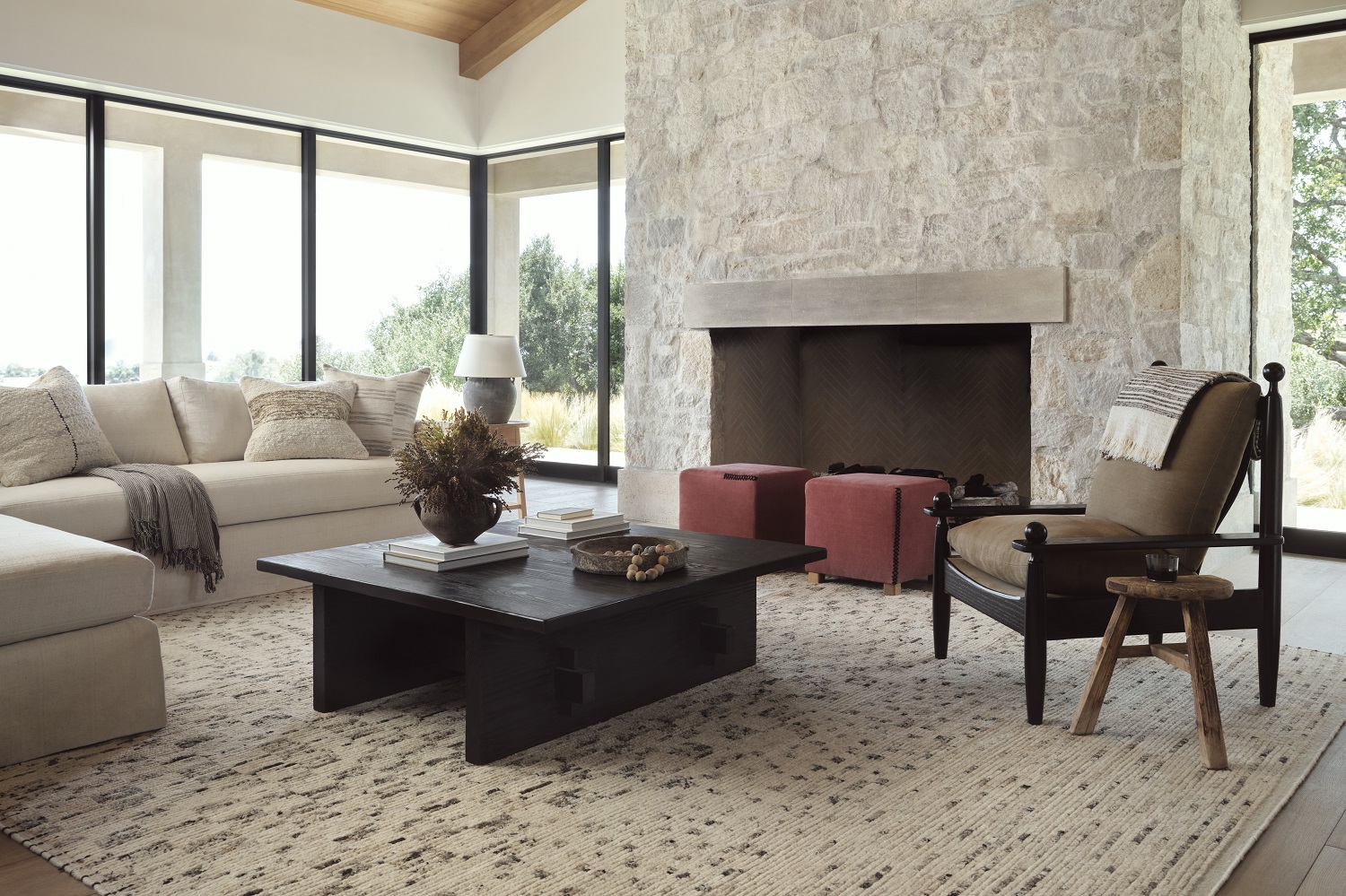 Cozy modern living room with stone fireplace, plush seating, and abundant natural light.