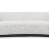 Modern minimalist sofa with rounded design, neutral upholstery, and dark wooden frame for contemporary spaces.