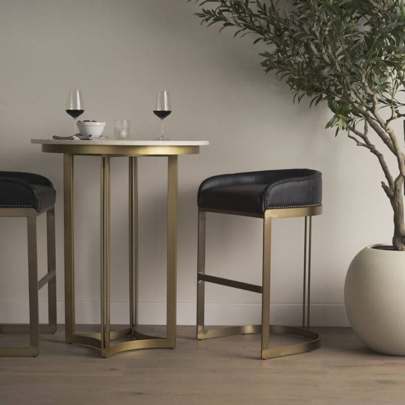 Modern dining setup with elegant bar stools, cozy wine glasses, and a touch of greenery.
