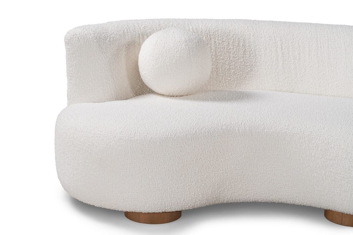 Modern white curvy sofa with a playful cushion, perfect for stylish contemporary living spaces.