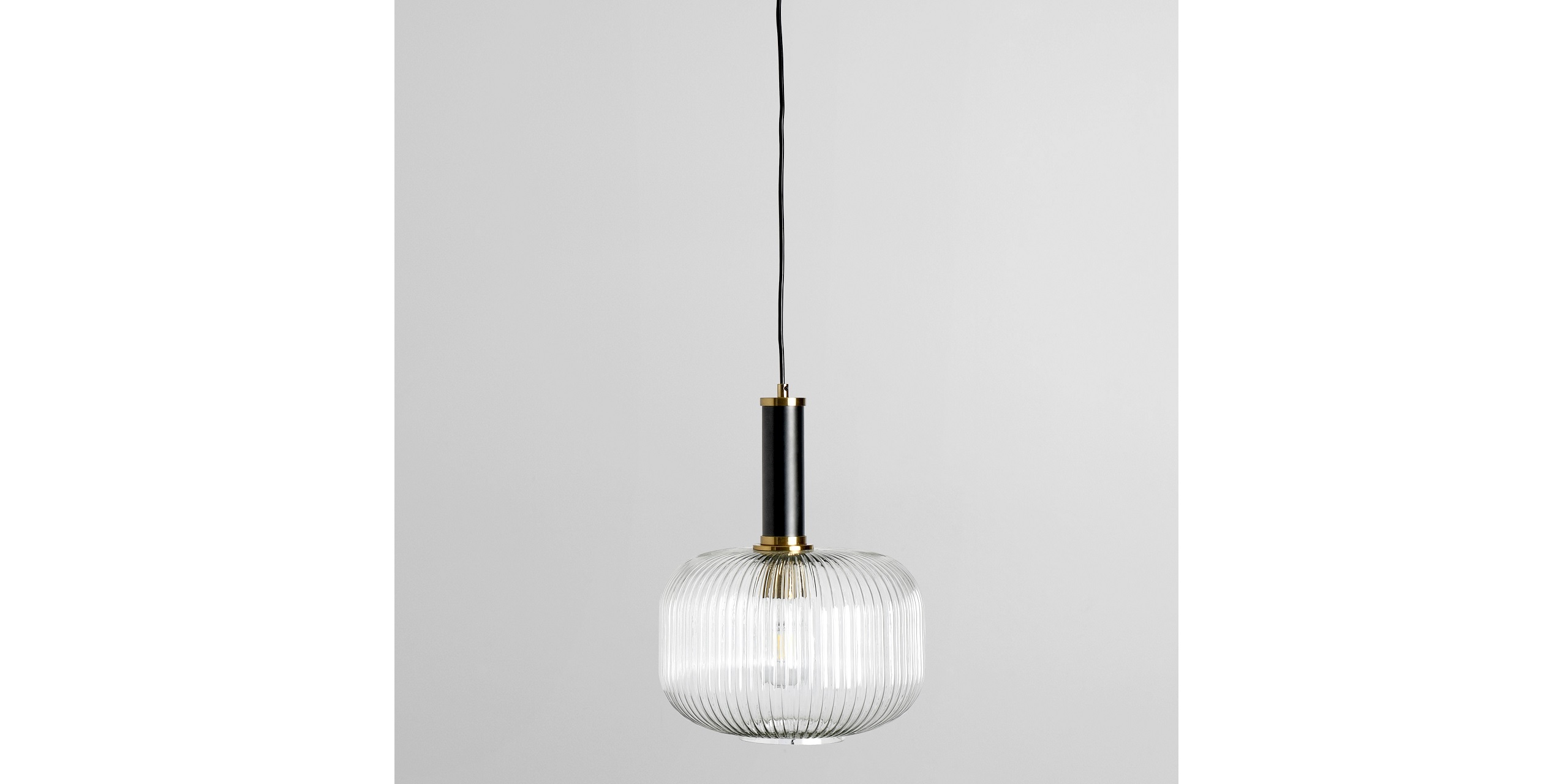 Sophisticated ribbed glass pendant light with black and gold accents for modern interiors.