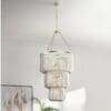 Stylish tiered chandelier with gold accents, casting beautiful light patterns in a modern space.