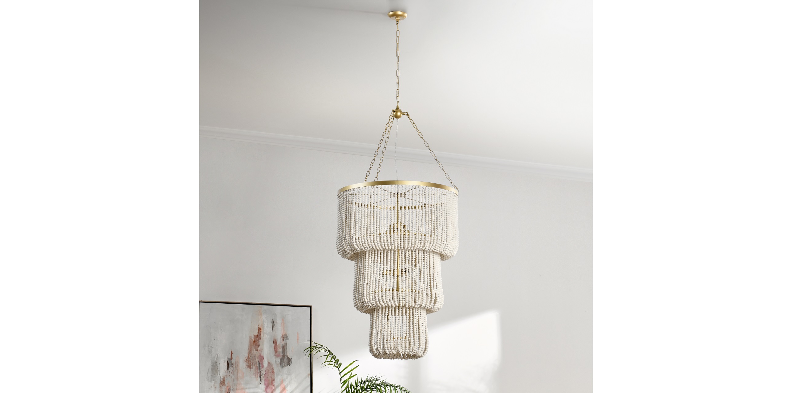 Stylish tiered chandelier with gold accents, casting beautiful light patterns in a modern space.