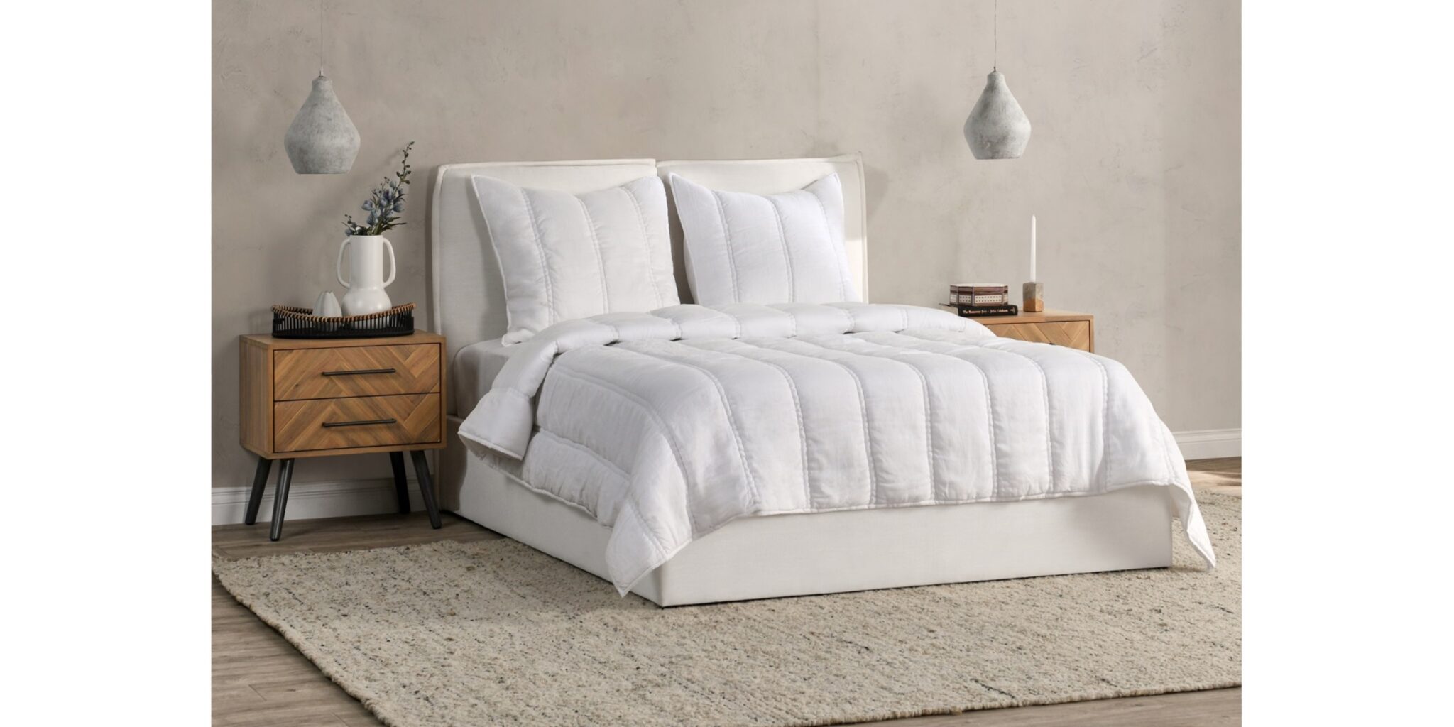 Cozy minimalist bedroom with plush bedding, modern nightstands, and warm pendant lighting for relaxation.
