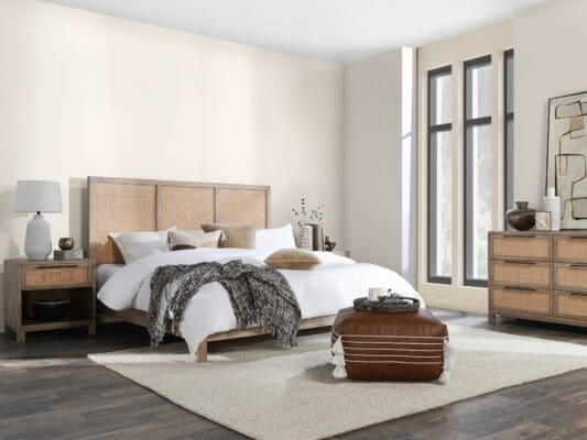 Modern bedroom with queen bed, natural light, and textured elements for a serene atmosphere.