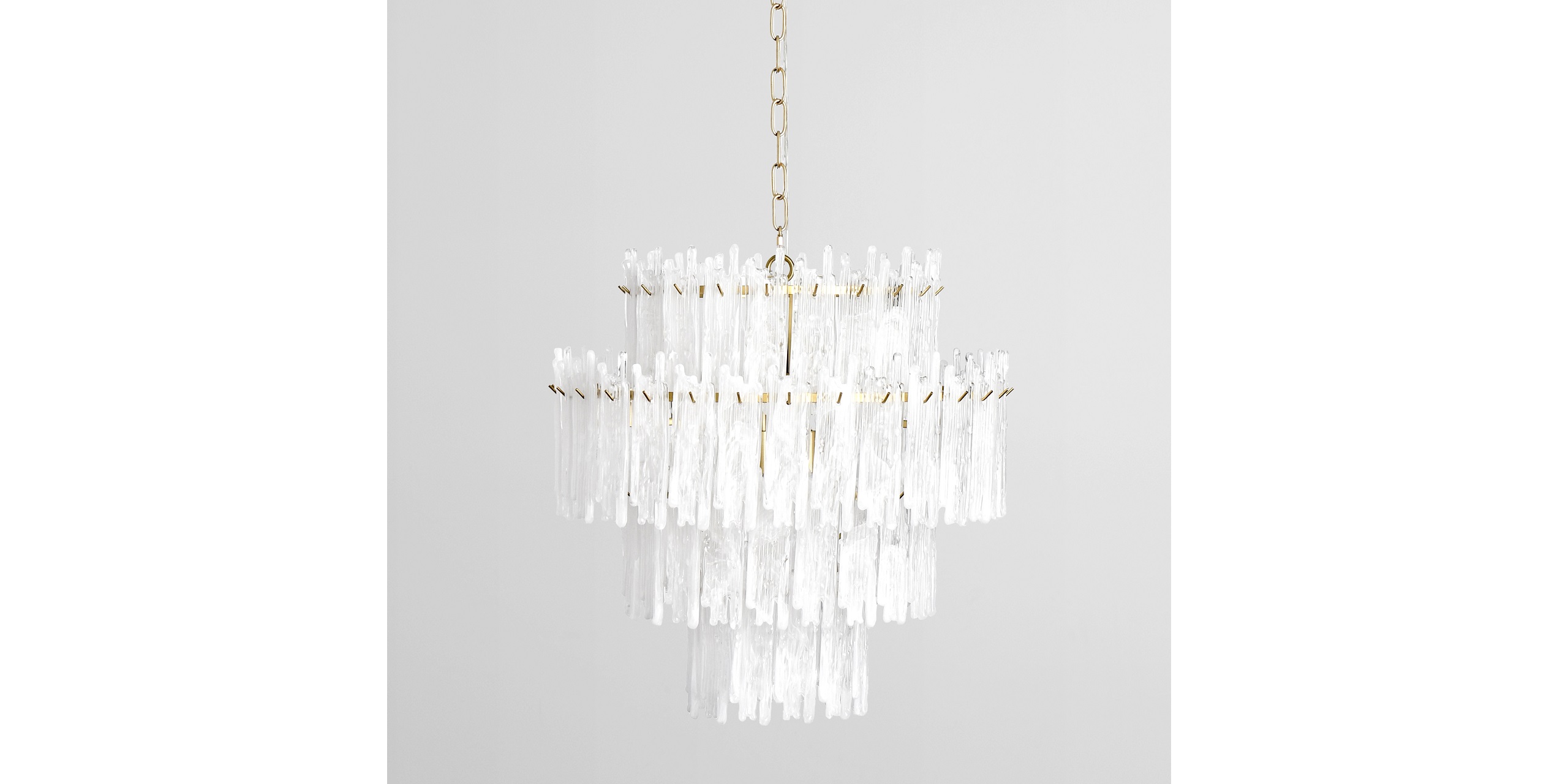Sleek modern chandelier with icicle design, gold frame, and stunning light-reflecting elements.