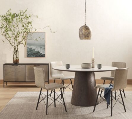 Modern dining area featuring a round table, beige chairs, and natural decor for a serene ambiance.