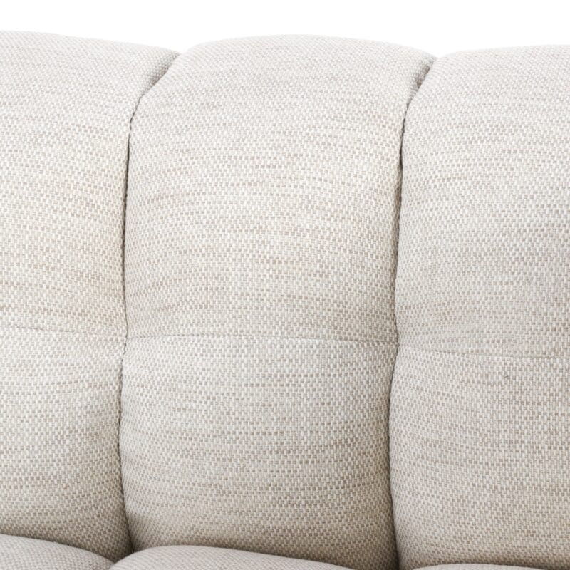 Elegant cream sofa with textured upholstery, tufted cushions, and a cozy, inviting design.