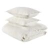 Cozy cream bedding arrangement with a folded duvet and decorative pillows for a serene bedroom.