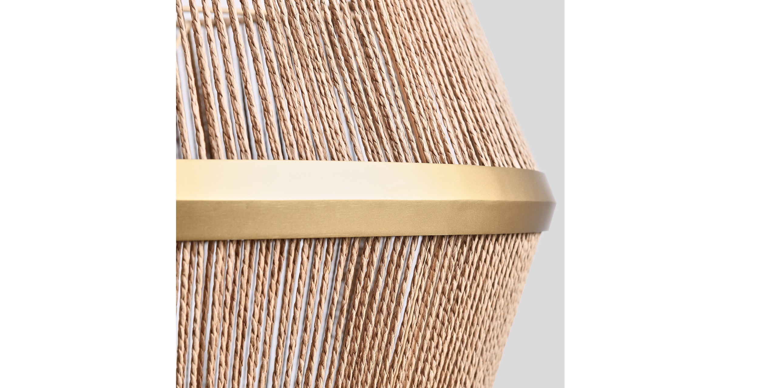 Stylish lamp design featuring natural fibers and a sleek metallic band against a gray backdrop.