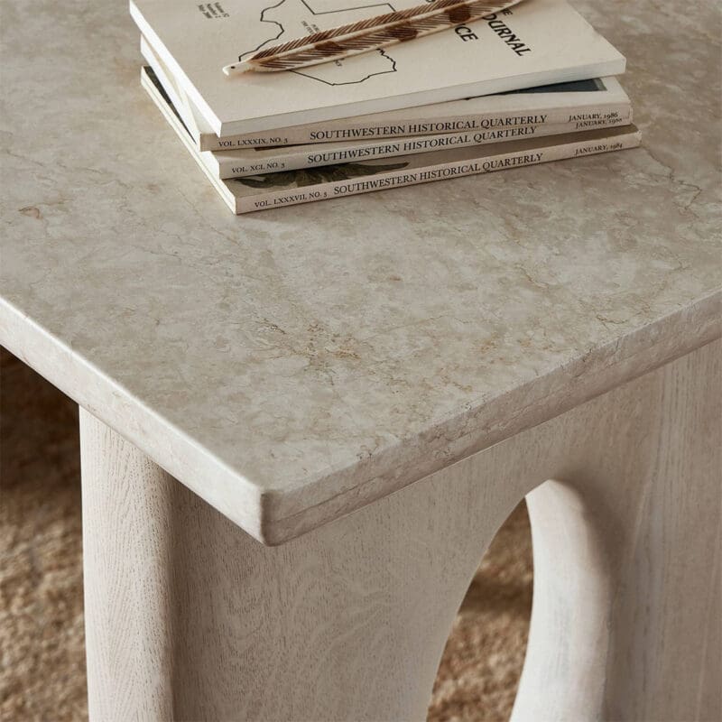 Chic coffee table with textured surface, stacked books, and cozy rug creating an inviting nook.