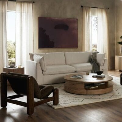 Contemporary living room featuring a light sectional sofa, bold accent chair, and natural light.