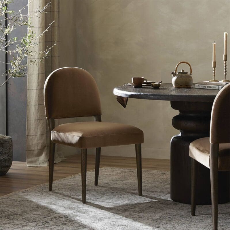 Stylish dining room with a round wooden table, leather chairs, and warm natural light.