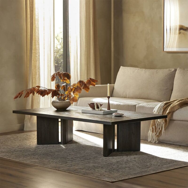 Elegant cozy living room with dark wood coffee table, light sofa, and warm natural light.