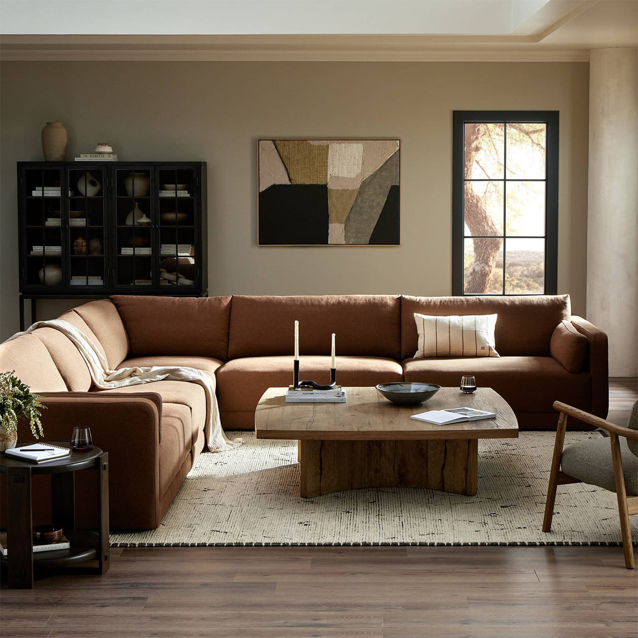 Warm and inviting living room featuring a brown sectional sofa and rustic decor.