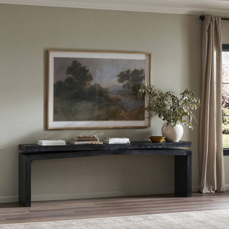Elegant minimalist interior with a dark console table, serene painting, and fresh greenery.