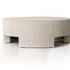 Stylish light gray round coffee table with textured sides and recessed legs for modern interiors.