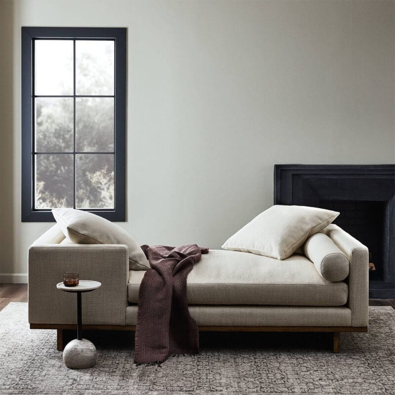 Stylish modern chaise lounge with cozy décor, natural light, and a warm fireplace ambiance.