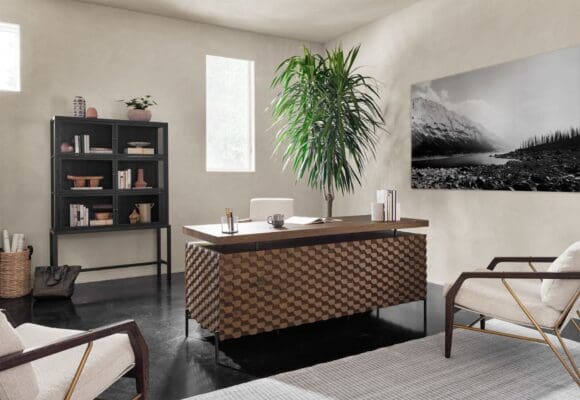Chic office space with geometric desk, cozy seating, and natural light for productivity and comfort.