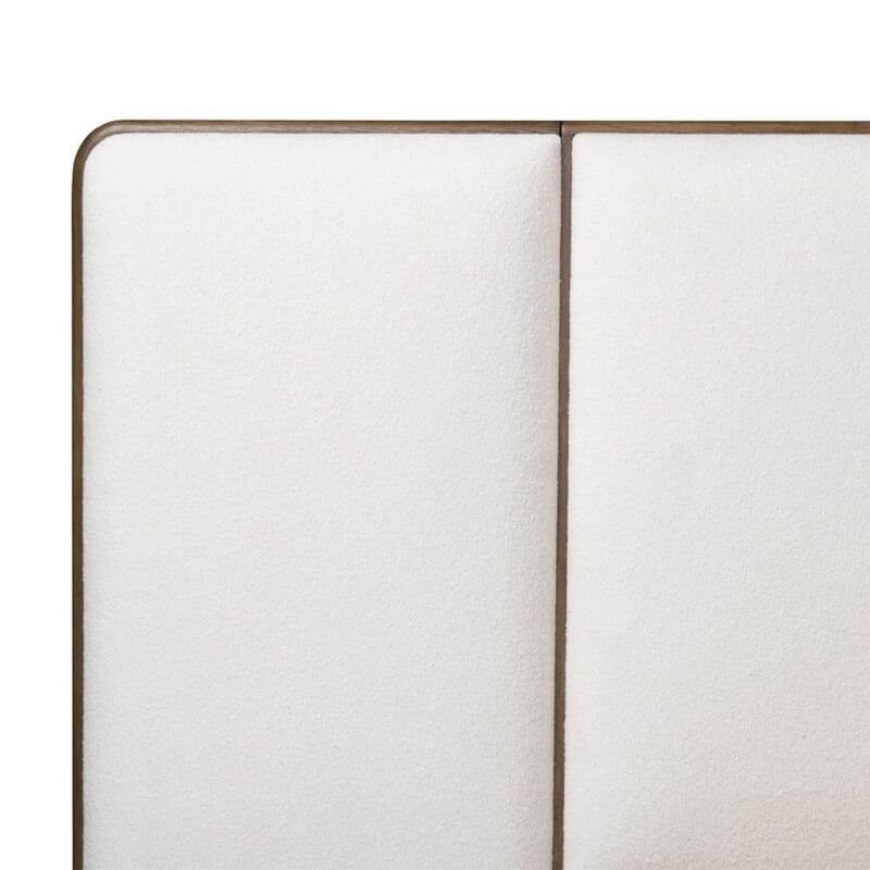 Modern cream upholstered headboard with symmetrical design and sleek matte bronze frame.