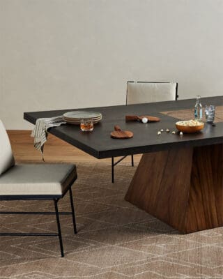 Elegant modern dining setup with dark table, cozy seating, and inviting atmosphere for gatherings.
