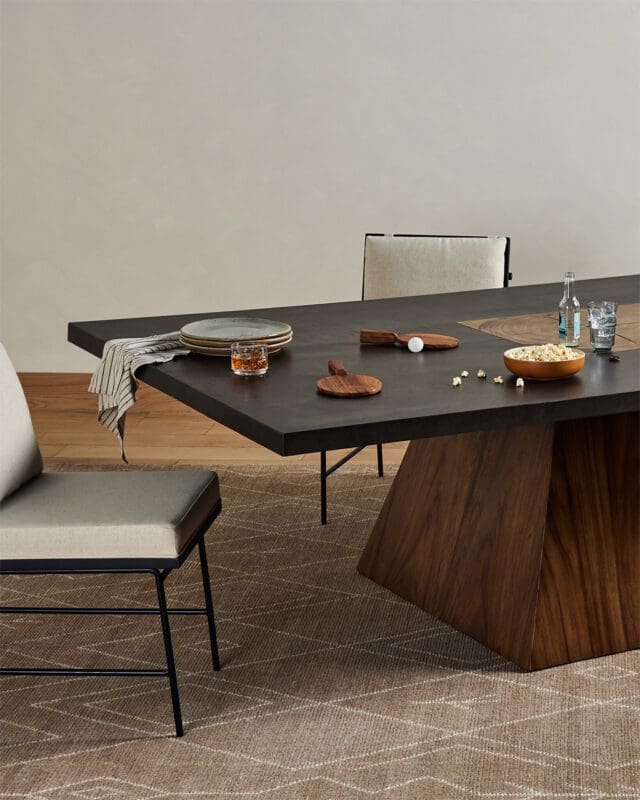 Elegant modern dining setup with dark table, cozy seating, and inviting atmosphere for gatherings.