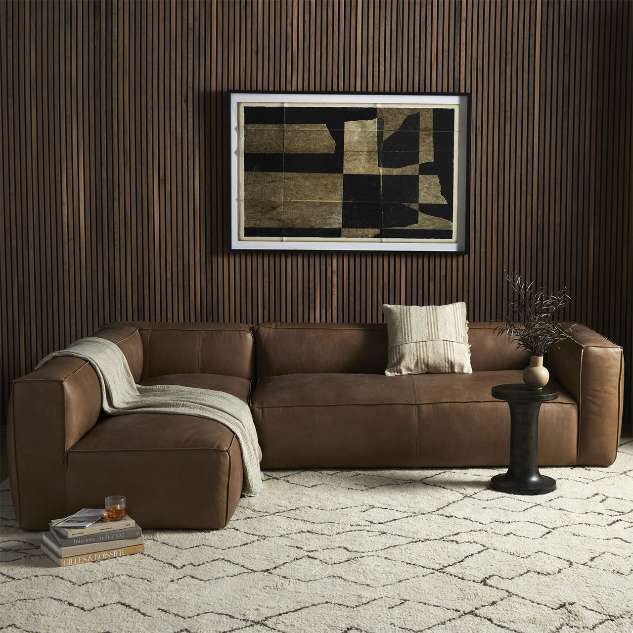 Stylish living room with a modern brown leather sectional and textured wood paneling.