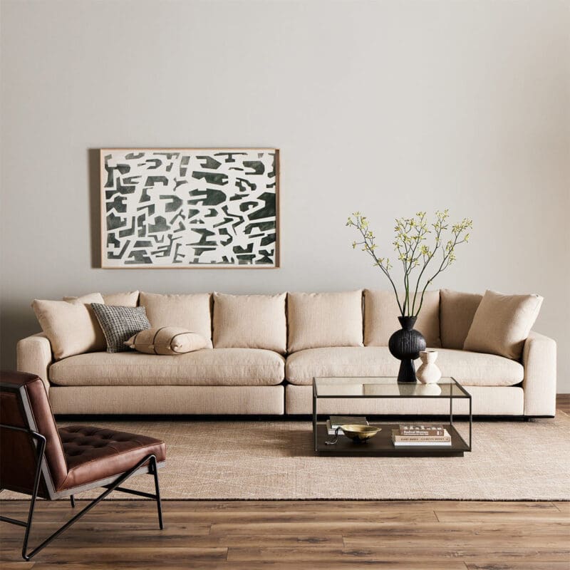 Cozy modern living room with beige sectional sofa, abstract art, and stylish mid-century chair.