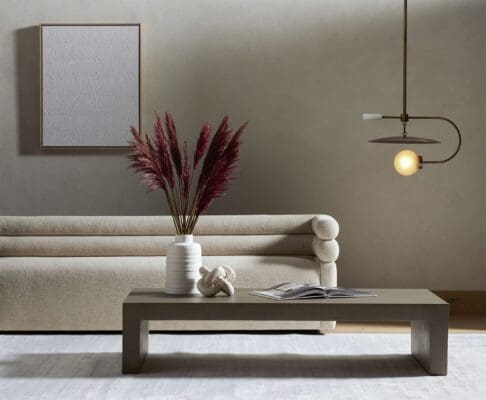 Stylish minimalist living room featuring a gray coffee table, beige sofa, and vibrant pampas grass.