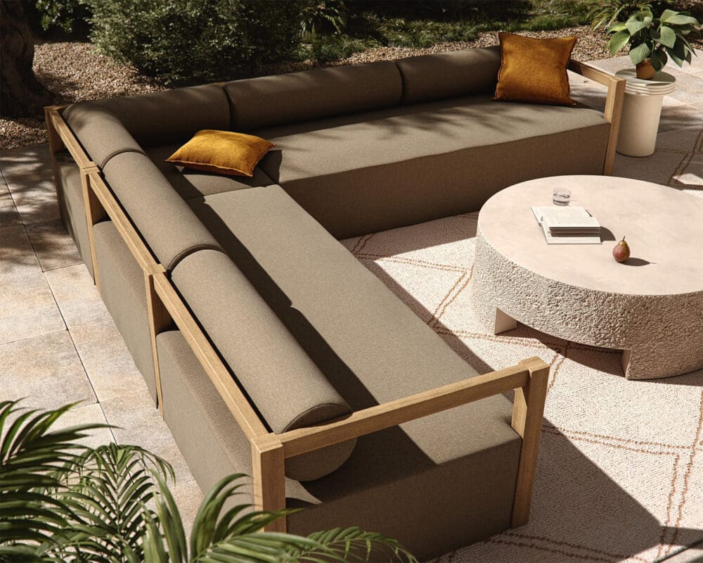 Inviting outdoor seating with sectional sofa, round table, and vibrant mustard-yellow accents.
