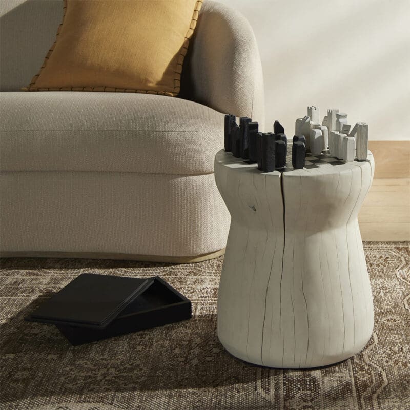 Modern tree stump side table with urban skyline sculptures in a cozy interior setting.