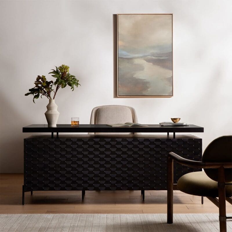 Sleek modern workspace with a textured black desk, light chair, and inviting natural elements.