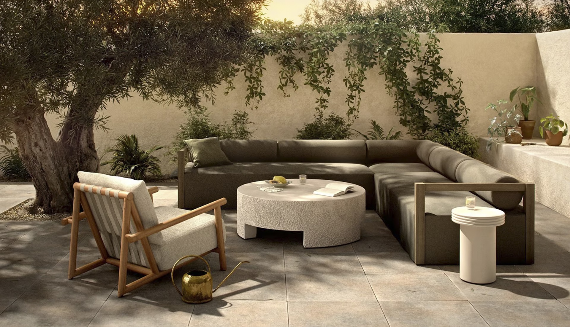 Elegant outdoor living space with a green sectional, stone coffee table, and lush greenery.