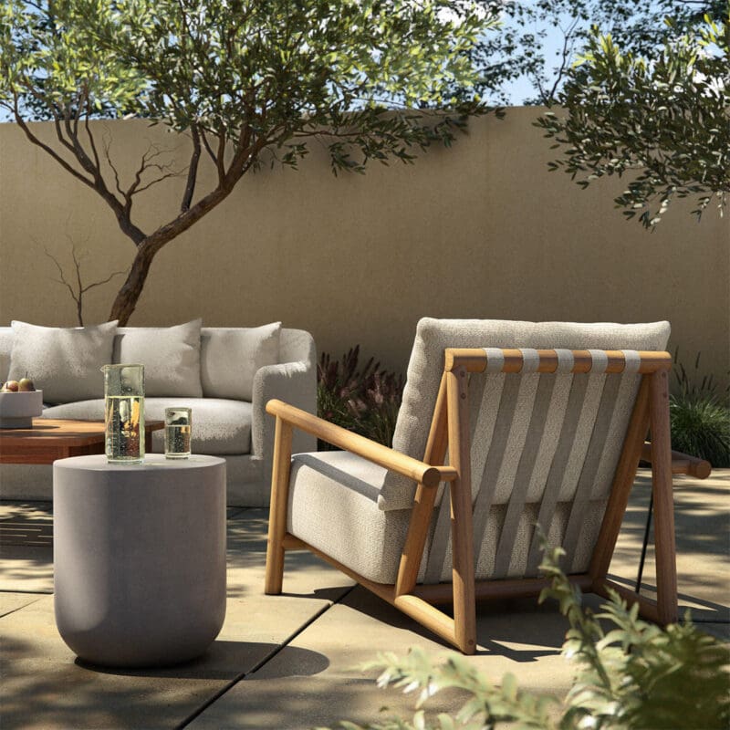 Cozy outdoor oasis with plush seating, lanterns, and lush greenery for relaxation and socializing.