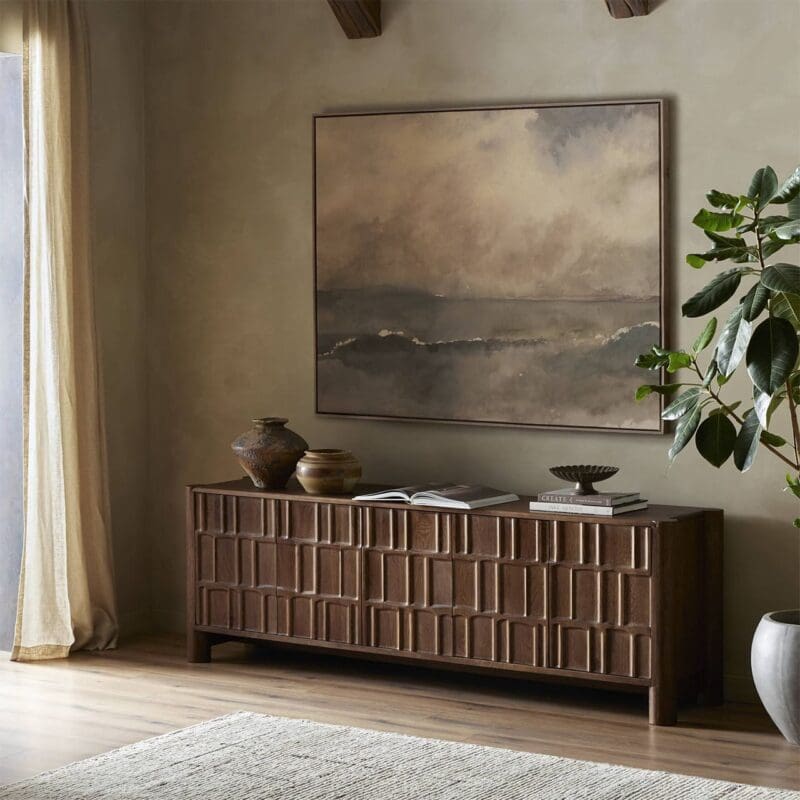 Tranquil interior with wooden sideboard, abstract art, and vibrant greenery under soft natural light.