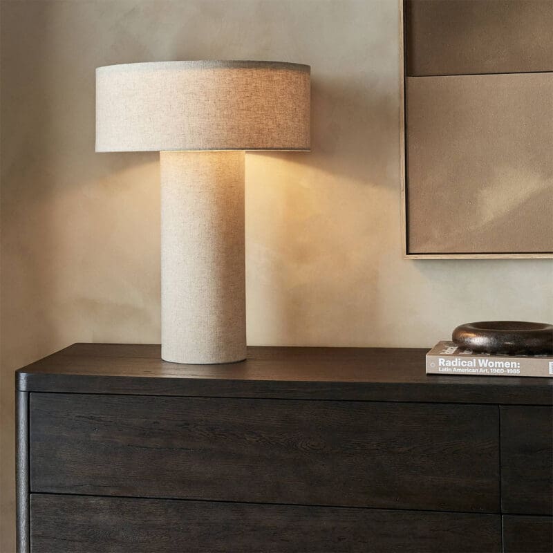 Stylish table lamp and decor enhance cozy minimalist interior with inviting warm tones.