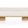 Elegant minimalist beige bench with plush cushion and wooden legs for modern interiors.