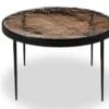 Modern round coffee table with textured, natural-looking surface and sleek black metal legs.