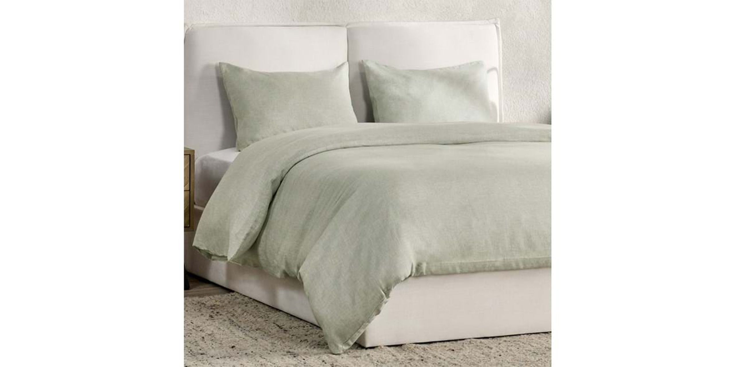 Tranquil bedroom with elegant light green bedding and a sleek white bed frame for relaxation.