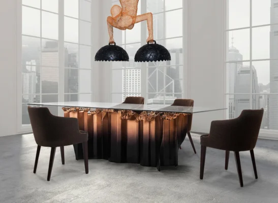 Contemporary dining area with glass table, artistic figures, and city skyline views.