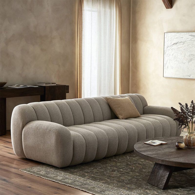 Cozy modern living room featuring a plush beige sofa, warm wooden floors, and elegant decor.