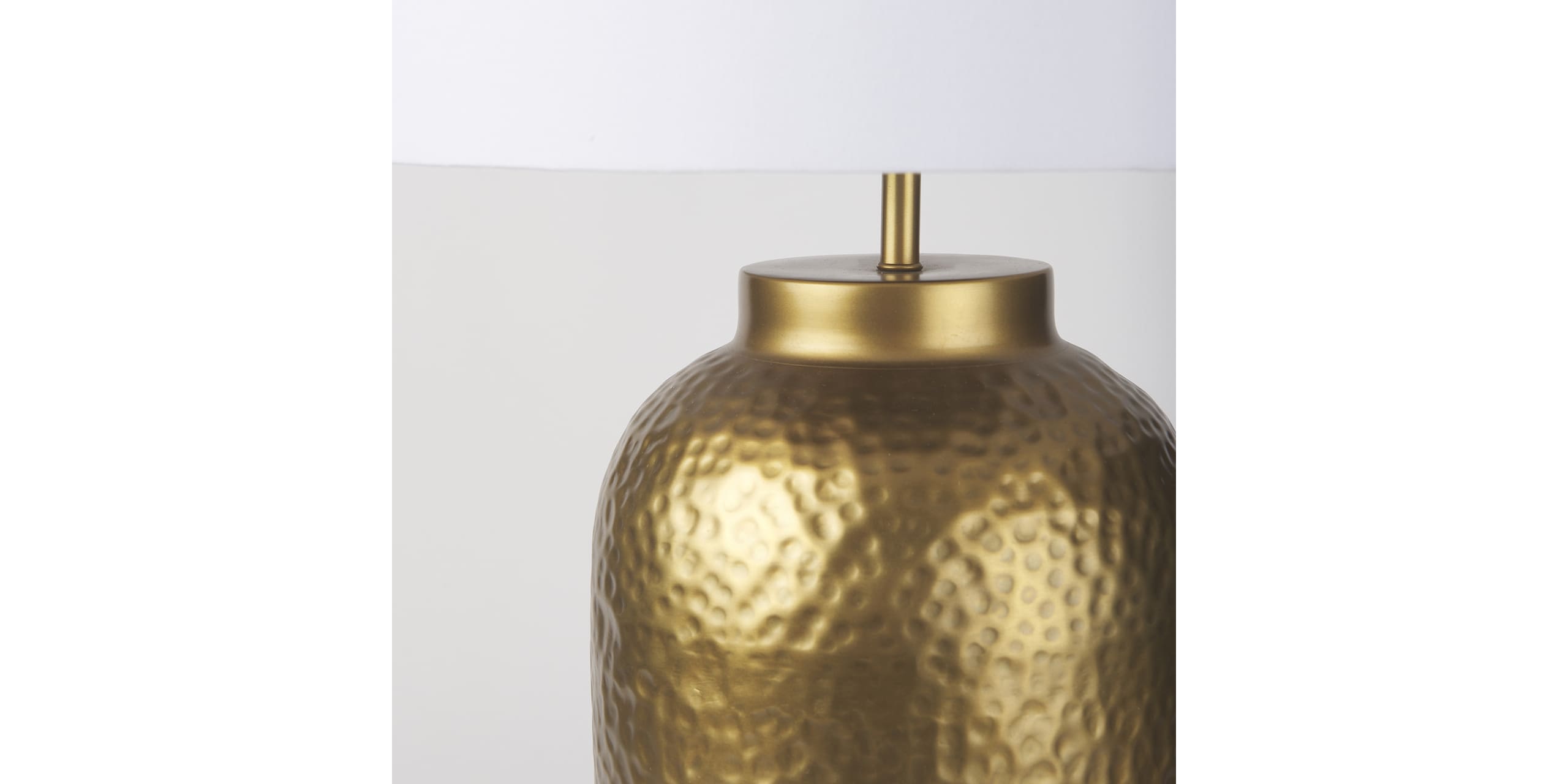 Stylish gold hammered lamp with white shade, perfect for enhancing any rooms decor.